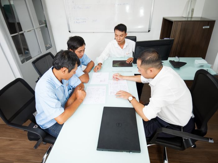 Equipo reunido planificando una estrategia junto a una pizarra